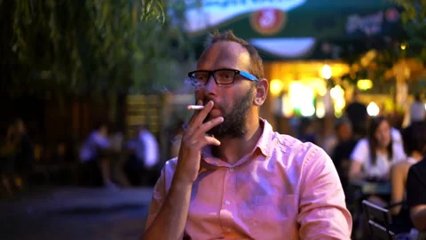 Young man smoking cigarette, drinking beer in the city Stock Footage 122728841