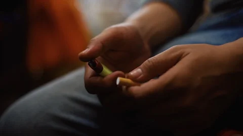 Young man smoking cigarette put his hand on the knee Stock Footage 93485290