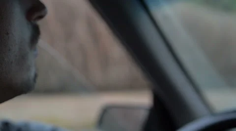 Young man smoking cigarette while driving in the sunrise Stock Footage 63301072