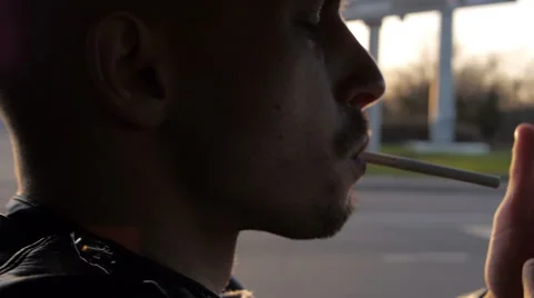 Young man smoking cigarette while driving in the sunrise. First-person view 库存影片 63301253