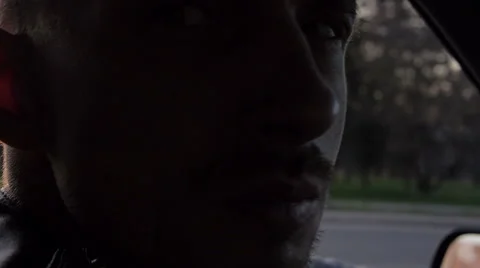 Young man smoking cigarette while driving in the sunrise. First-person view 库存影片 63301535