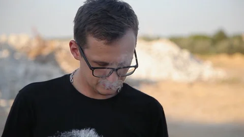 Young man smoking e-cig and relaxing in construction 1 Видео 94442266