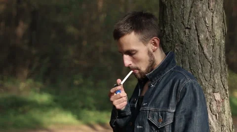 Young man smoking in forest Stock Footage 42774863