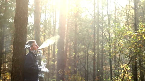 Young man smoking in forest Stock Footage 42776640