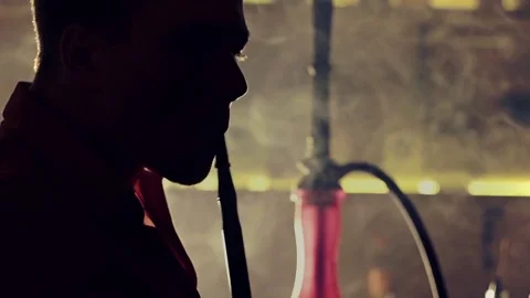 Young man smoking hookah in a bar Stock Footage 83535016