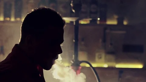 Young man smoking hookah in a bar Stock Footage 83535168