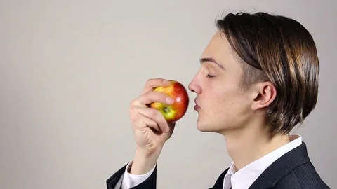 Young man sniffing an apple Stock Footage 73650537