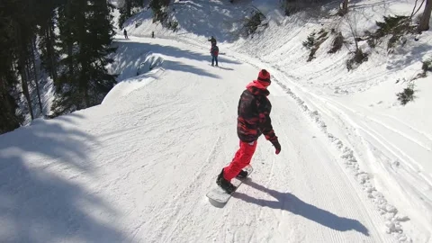 Young man snowboarding down the slope in mountains Stock Footage 218159581