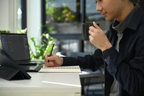 Young man software developers working with coded data on computer screen Stock Photos