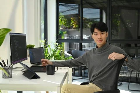 Young man software developers working with coded data on computer screen Stock Photos