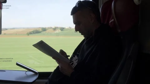 Young man solving crossword puzzle on train during journey Video stock 334775717