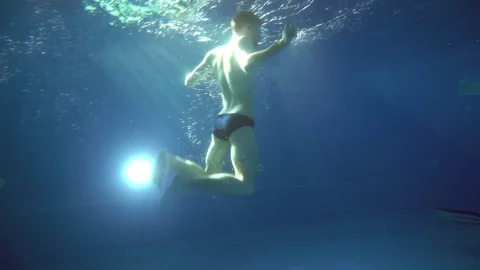 A young man somersaults and does a somersault under the water. He is posing in Video stock 75457912