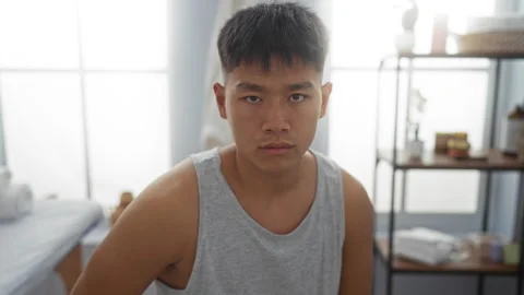 Young man in a spa room with a serious expression, featuring indoor wellnes.. 스톡 동영상 300299989