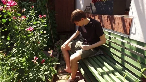 Young man spaying his arms and legs with water on a hot summer day Stock Footage 79613787