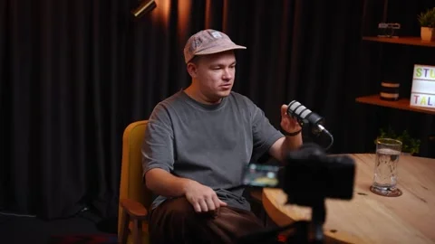 Young man speaking into a microphone during podcast recording Stock Footage 318781877