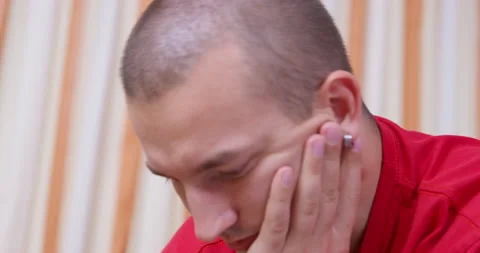 Young man speaks propping head with hand thoughtfully Video stock 219905383