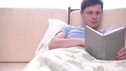 Young man spending a day in bed at home Stock Footage 72058539