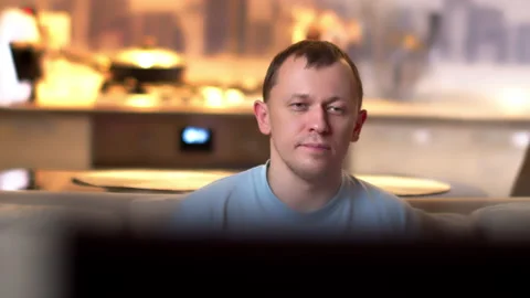 Young man spends the evening sitting at the TV, camera movement Stock Footage 136032077