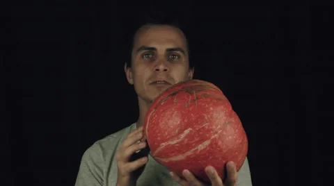 Young man spin pumpkin in hand, slowmotion Stock Footage 68185179