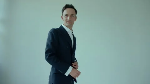 Young man spins around and poses in suit in studio, half body shot Stock Footage 268022249
