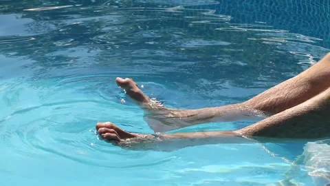 Young man splashing in summer in the pool Stock Footage 134480011