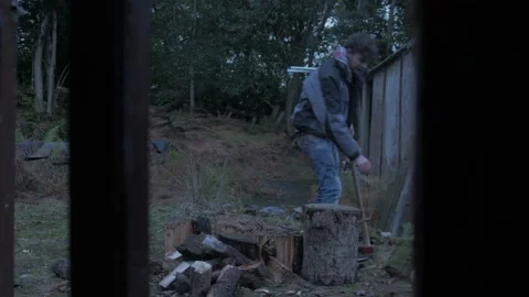Young man splits logs for firewood fuel source living within forest Video stock 221294330