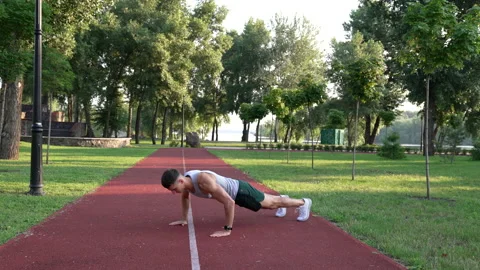 Young man sportsman doing burpee exercise in park outdoor, burpee Stock Footage
