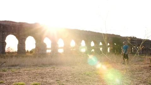 Young man in sportswear running along ancient roman aqueduct Appio Claudio Vídeo Stock 84265767