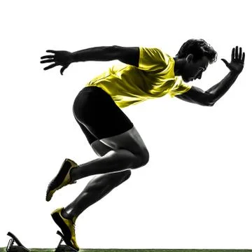 Young man sprinter runner in starting blocks silhouette Stock Photos