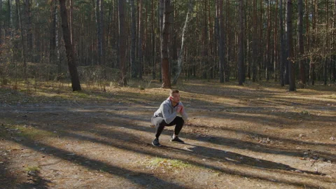 Young Man Is Squatting In Forest Video stock 166504178