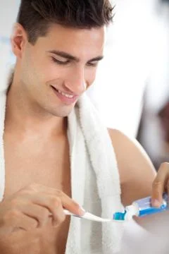 Young man squeezes toothpaste on the brush 스톡 사진
