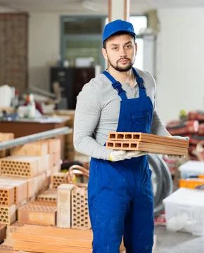 Young man stacking bricks at construction site Stock Photos