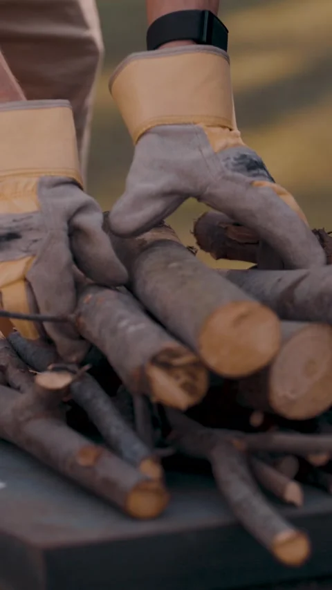Young man stacking firewood close-up vertical video Stock Footage 287668638