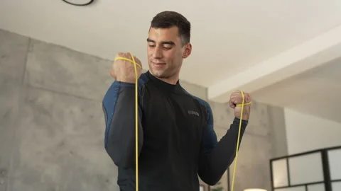 Young man stand and exercise with rubber resistance elastic band Stock Footage 278333011