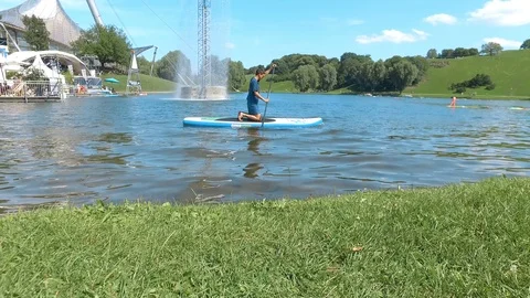 Young man Stand up paddle board on the lake in Olympia park Stock Footage 106645490