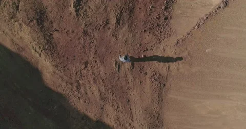 Young man standing and walking in abandoned land like desert or another planet Stock Footage 163550989