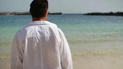 Young man standing on the beach  HD Stock Footage 10901818