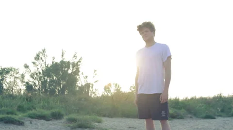 Young man standing on the beach looking in the distance Stock Footage 40806664