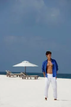 Young man standing on beach Stock Photos