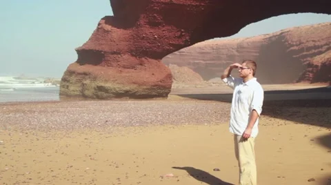 Young man standing on the beach, steadicam shot Stockbeeldmateriaal 10892263