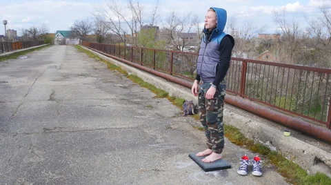 A young man standing on a bed of nails, smiling Stock Footage 68348929