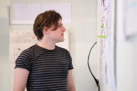 A young man is standing at the booth developing concepts of business. Stock Photos