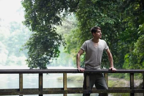 Young man standing on bridge Stock Photos
