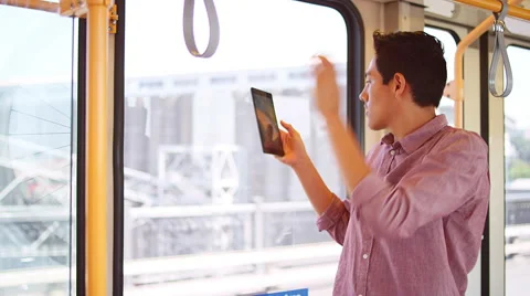 A young man standing on a bus and taking photos out the window with a tablet Stock Footage 57513078