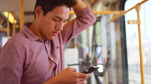 A young man standing on a bus and using his phone Video stock 57625980