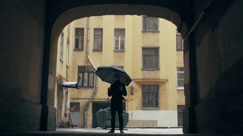 Young man standing with cup of coffee under heavy snowfall, holding umbrella Stock Footage 74894794
