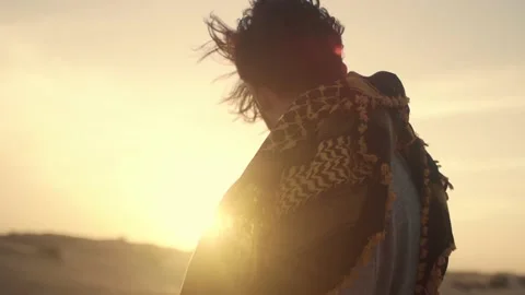 Young man standing in the Desert and looking at the sunset . Stock Footage 239093539