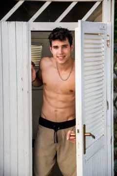 Young Man Standing in Doorway of Rustic Beach Hut Stock Photos