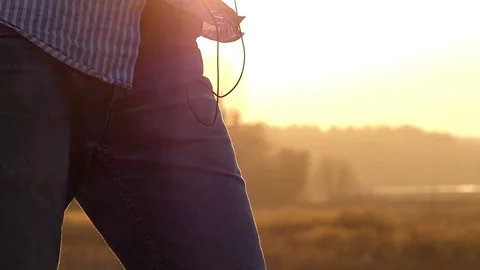 Young Man is Standing With Earbuds in Ears and a Player in Hands With the Sunny Stock Footage