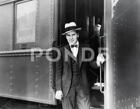 Young man standing at the entrance of a train Stock Photos